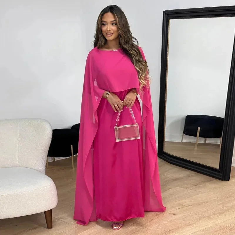 Model wearing cape maxi dress, front-facing pose with draped sleeves