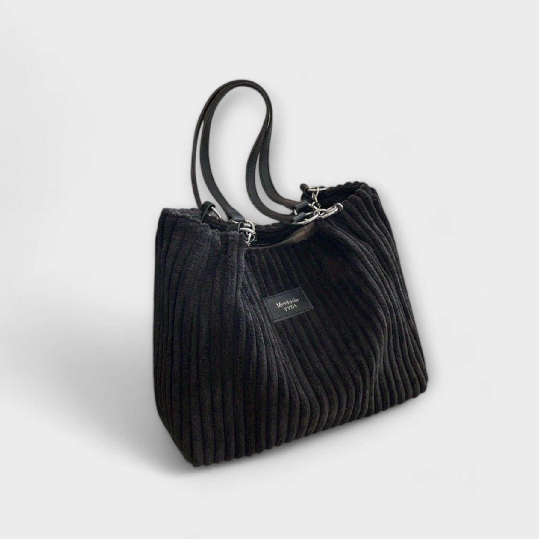 Woman holding bag with fabric shoulder strap, angled view