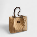 Woman wearing corduroy bag across body, casual pose