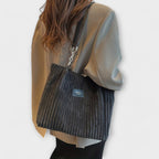 Close-up of vertical ribbed texture and dual chain strap detail