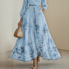 Three-quarter view of model in floral pleated dress