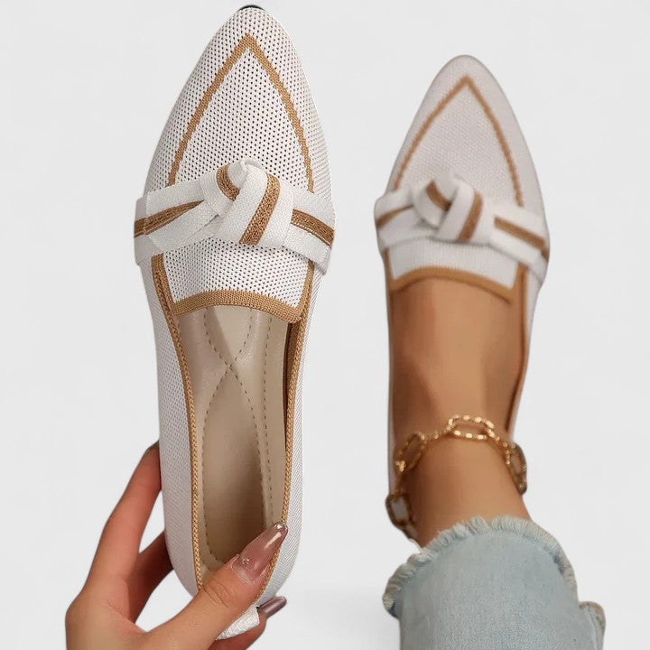 Loafers worn on feet, showing bow detail and pointed toe silhouette