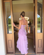 Model wearing halter maxi dress showing side profile and ruffle layers