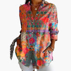 Model wearing abstract blouse, front view with collared neckline and button closure