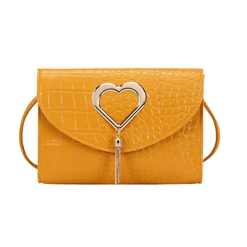 Mustard yellow croc embossed crossbody bag with silver heart clasp, front view