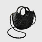 Model carrying woven straw bag on shoulder with strap