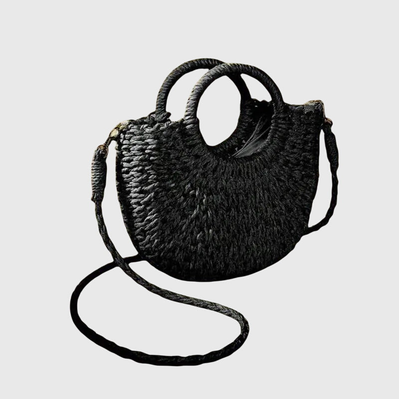 Model carrying woven straw bag on shoulder with strap