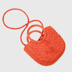 Model wearing straw bag as crossbody with detachable strap