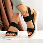 Model wearing navy platform sandals with elastic straps, side pose