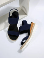 Model walking in navy elastic strap platform sandals, outdoor setting