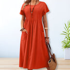 Model wearing pleated midi dress, standing pose showing drape and silhouette