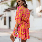 Model wearing floral mini dress with batwing sleeves and empire waistline