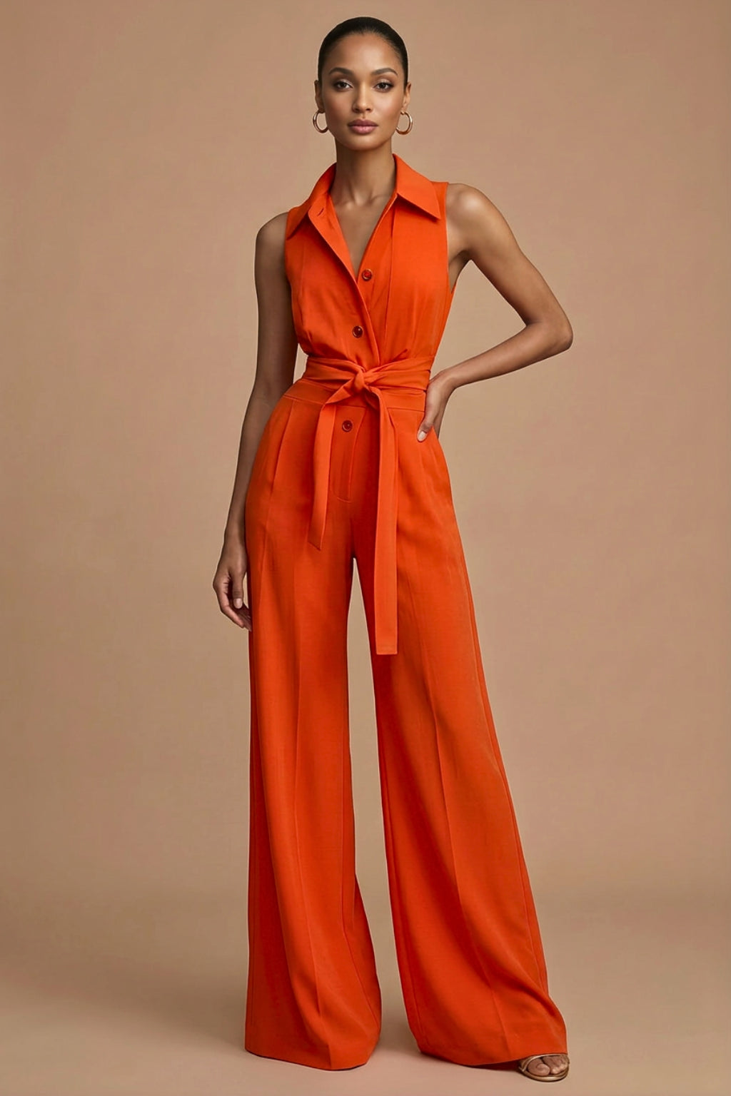 Woman wearing orange sleeveless wide leg jumpsuit with collared neckline, front view