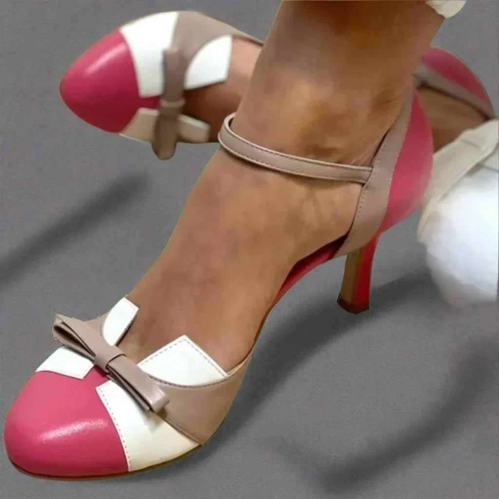 Model wearing bow strap pumps, front pose on steps