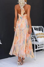 Model wearing halter neck maxi dress, side profile showing open back detail