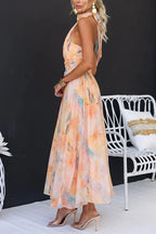 Model in peach watercolour maxi dress, rear view showing open back design