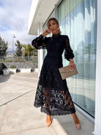 Model wearing dress in garden setting, full-length pose