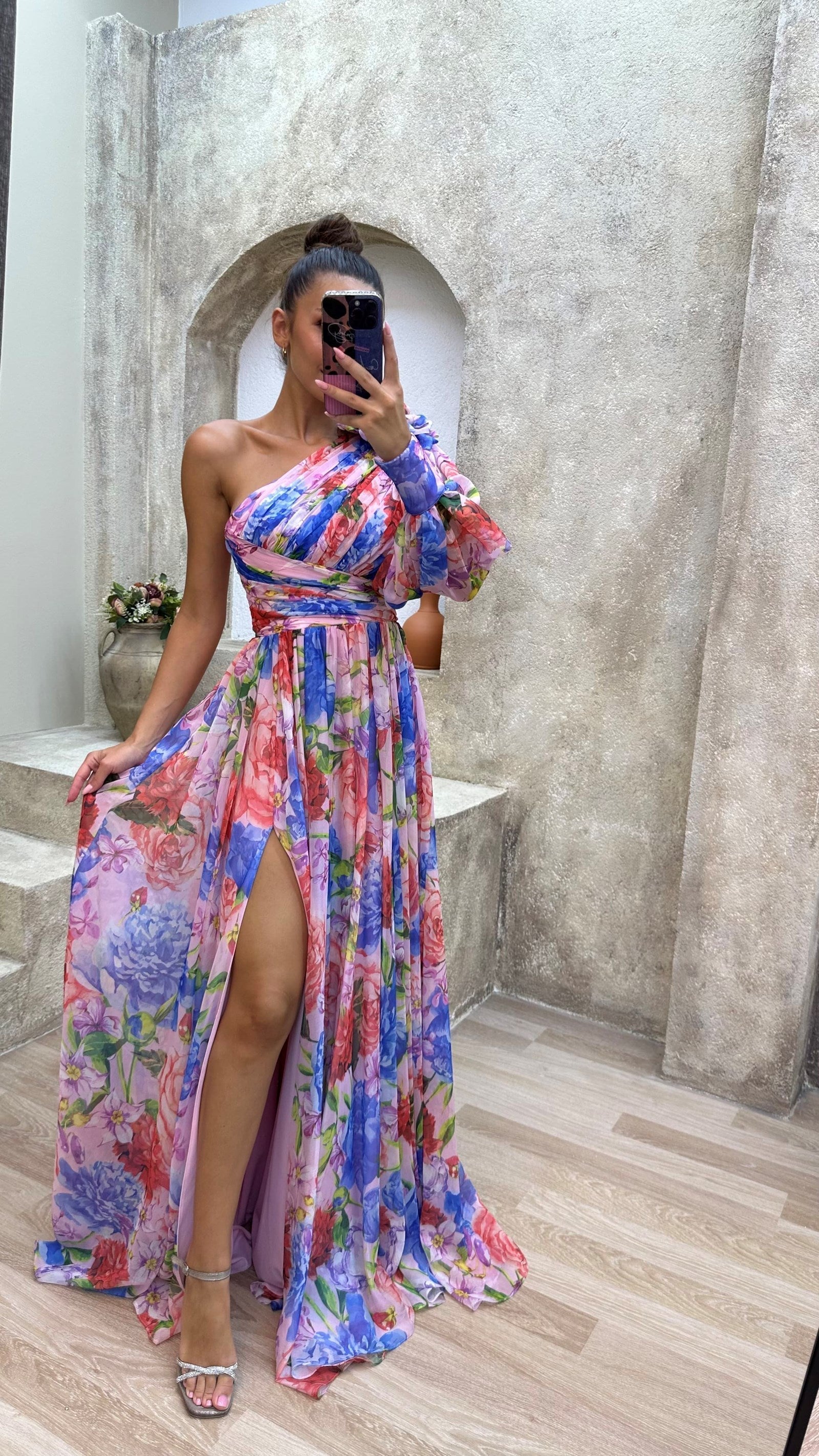 Model posing in floral one shoulder dress, three-quarter length angle