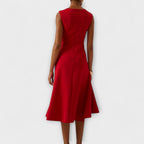 Model wearing asymmetric midi dress in standing pose showing drape detail
