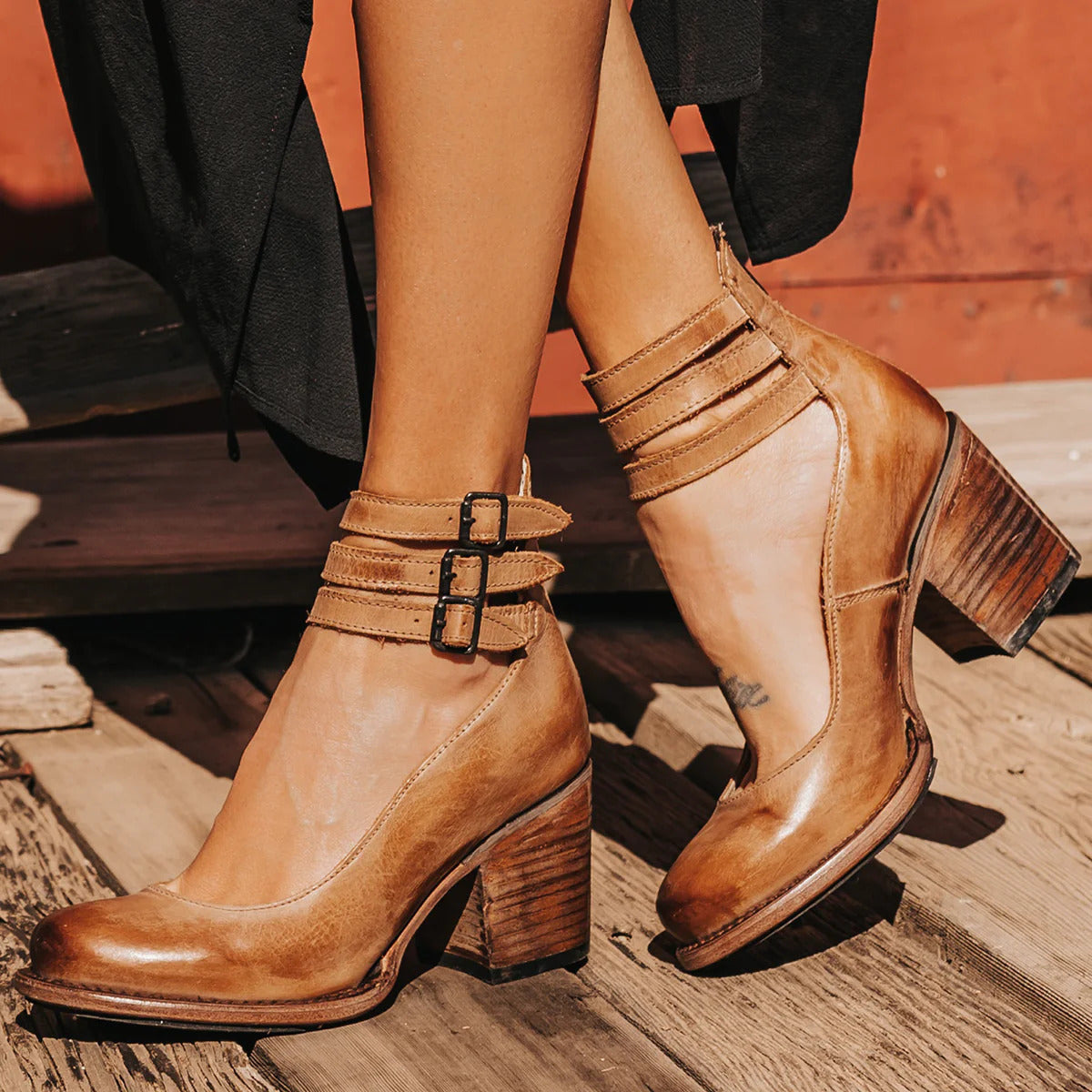 Tan brown leather ankle boots with block heel and dual buckle straps, front view