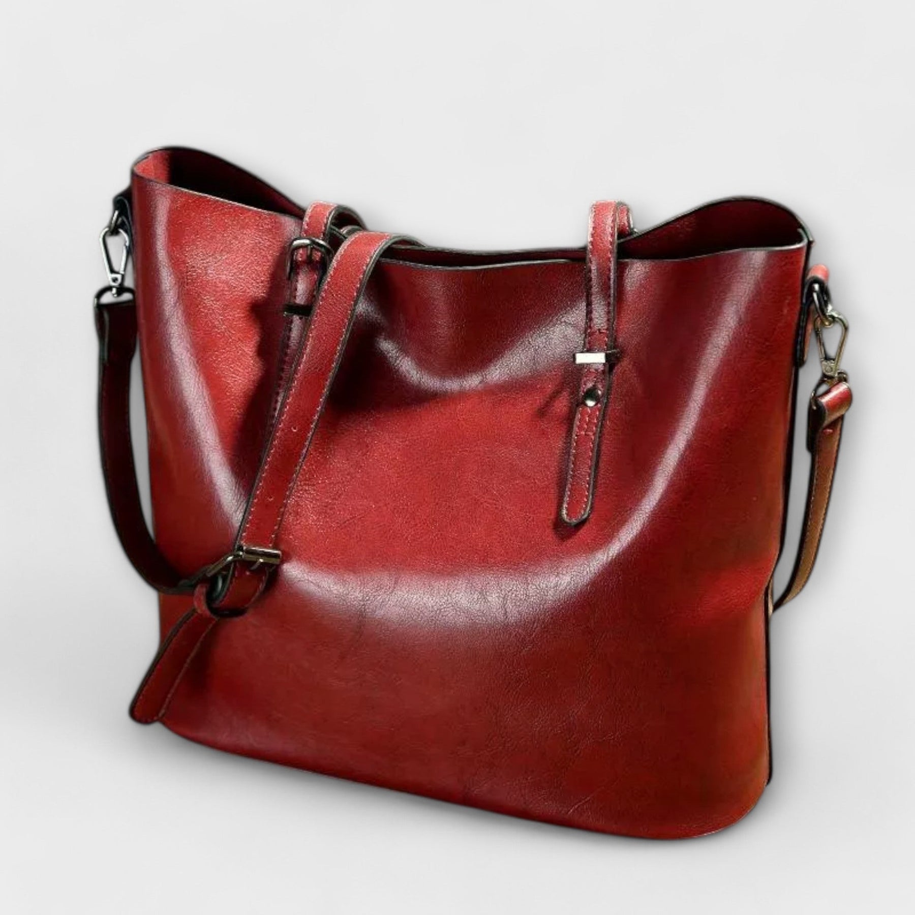 Woman holding tan leather tote with both handles, standing pose