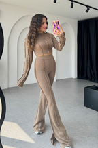 Women's taupe knit cropped top and flare trousers set displayed on model