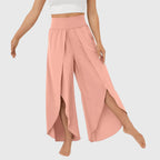 Model seated wearing teal wide leg trousers