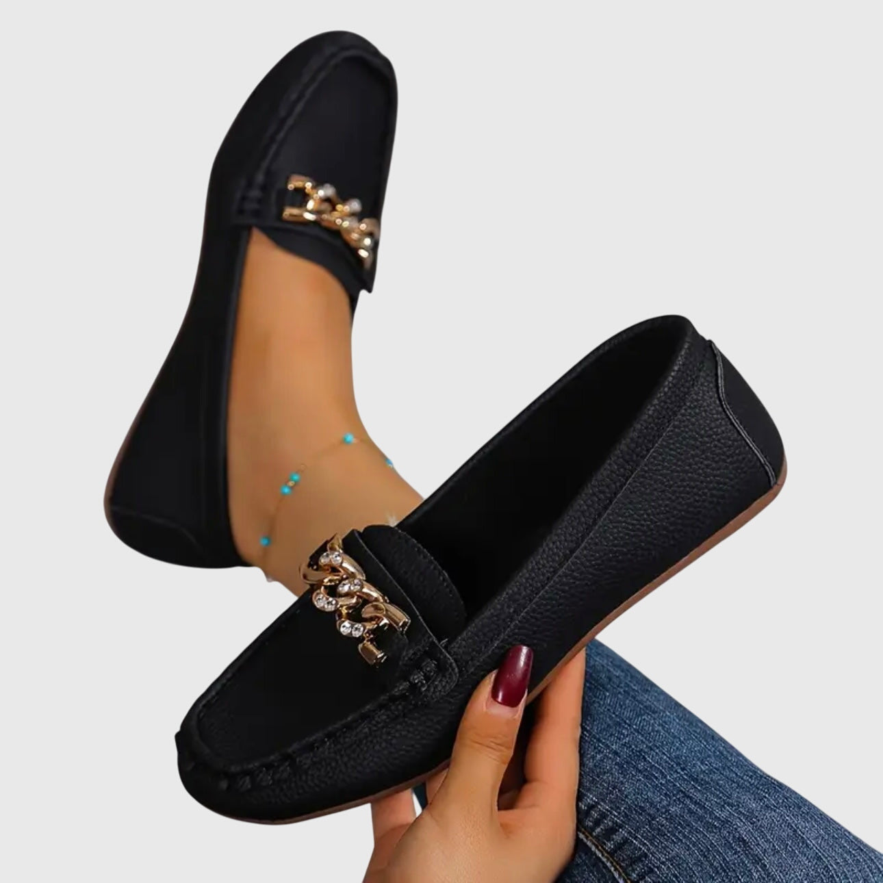 Woman sitting down showcasing white chain loafers