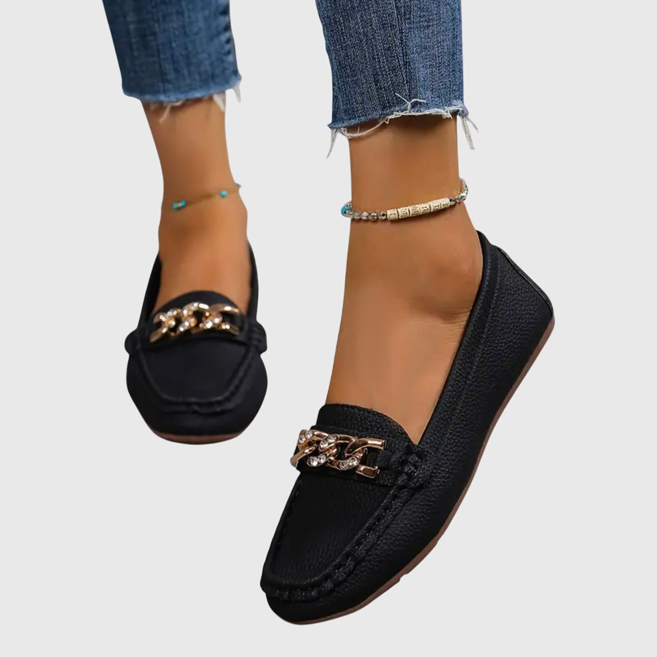 Pair of white chain loafers on neutral background