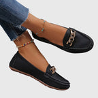 Woman wearing white chain loafers, standing pose