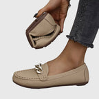 Woman in casual outfit walking in white chain loafers