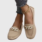 Top-down view of white chain loafers