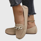 Woman wearing white chain loafers with trousers