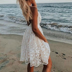 Model wearing white lace mini dress, front pose showing V-neckline and empire waistline