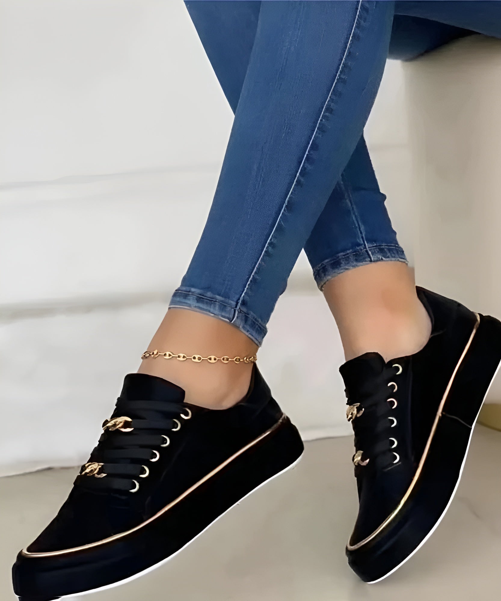 Model wearing white trainers with gold accents, standing pose