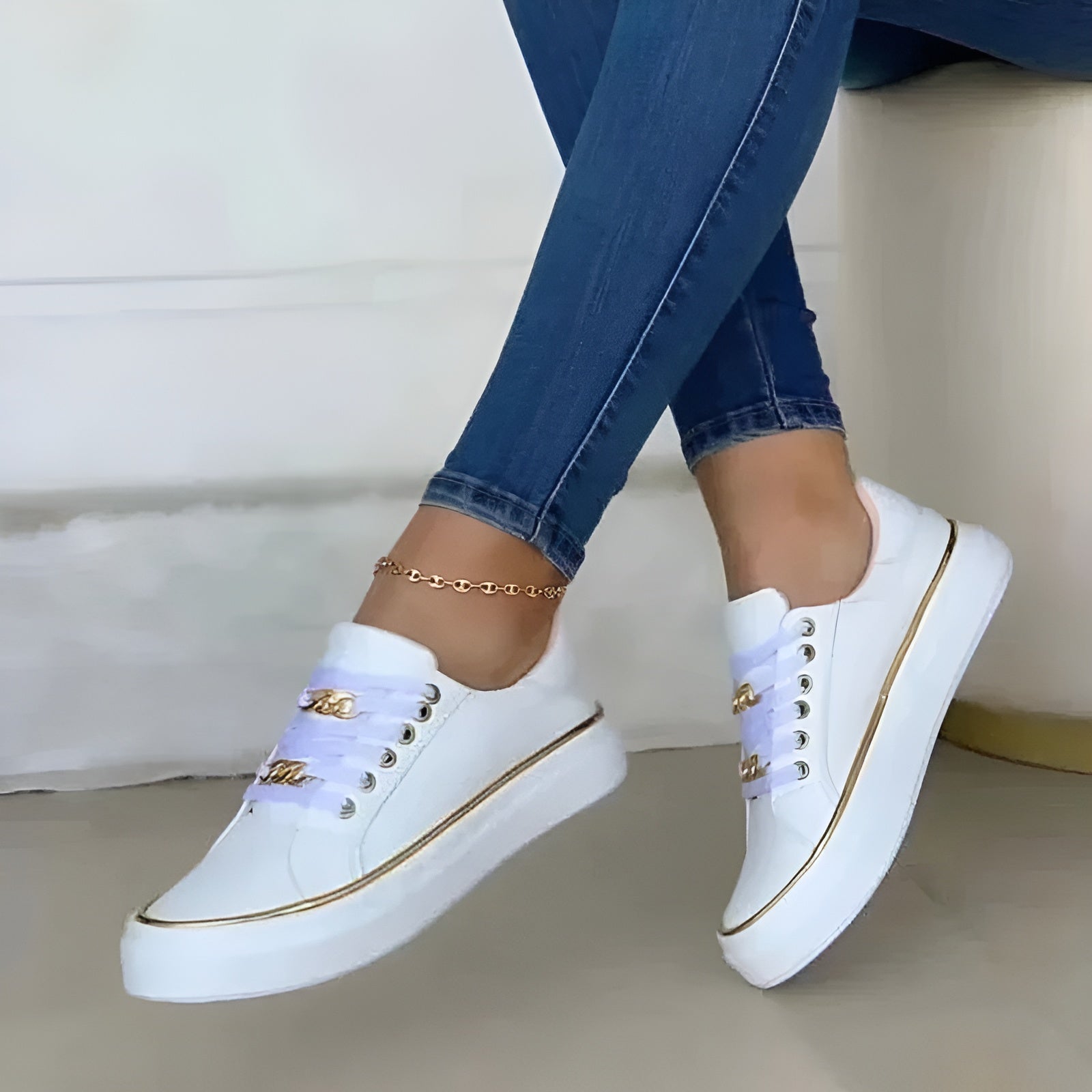 White trainer showing metallic trim and lace-up closure detail