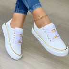 White lace-up trainer with gold chain detail, side view