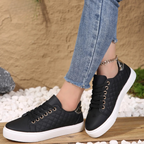 Woman wearing white quilted platform trainers with jeans, side angle