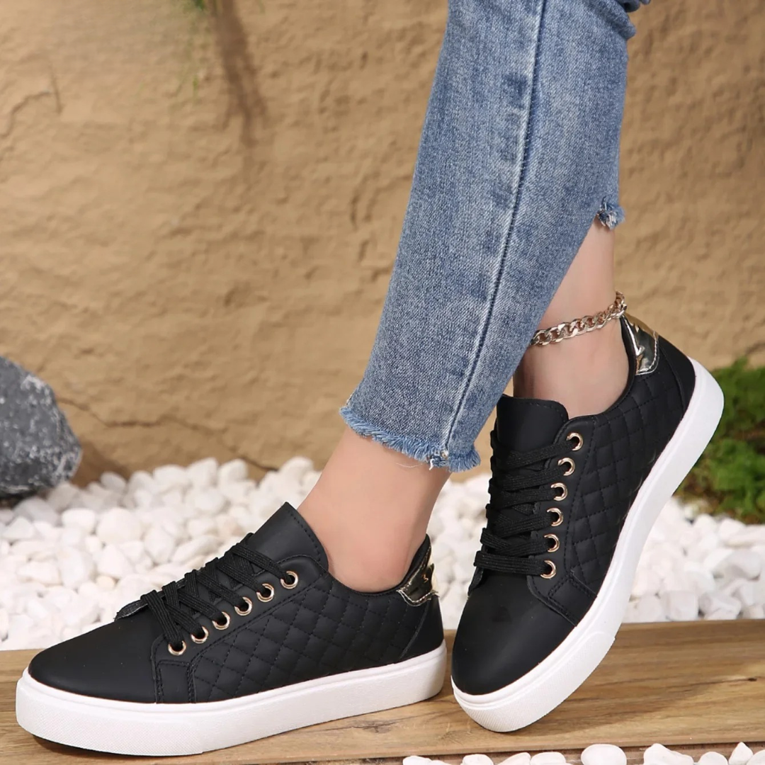 Woman wearing white quilted platform trainers with jeans, side angle