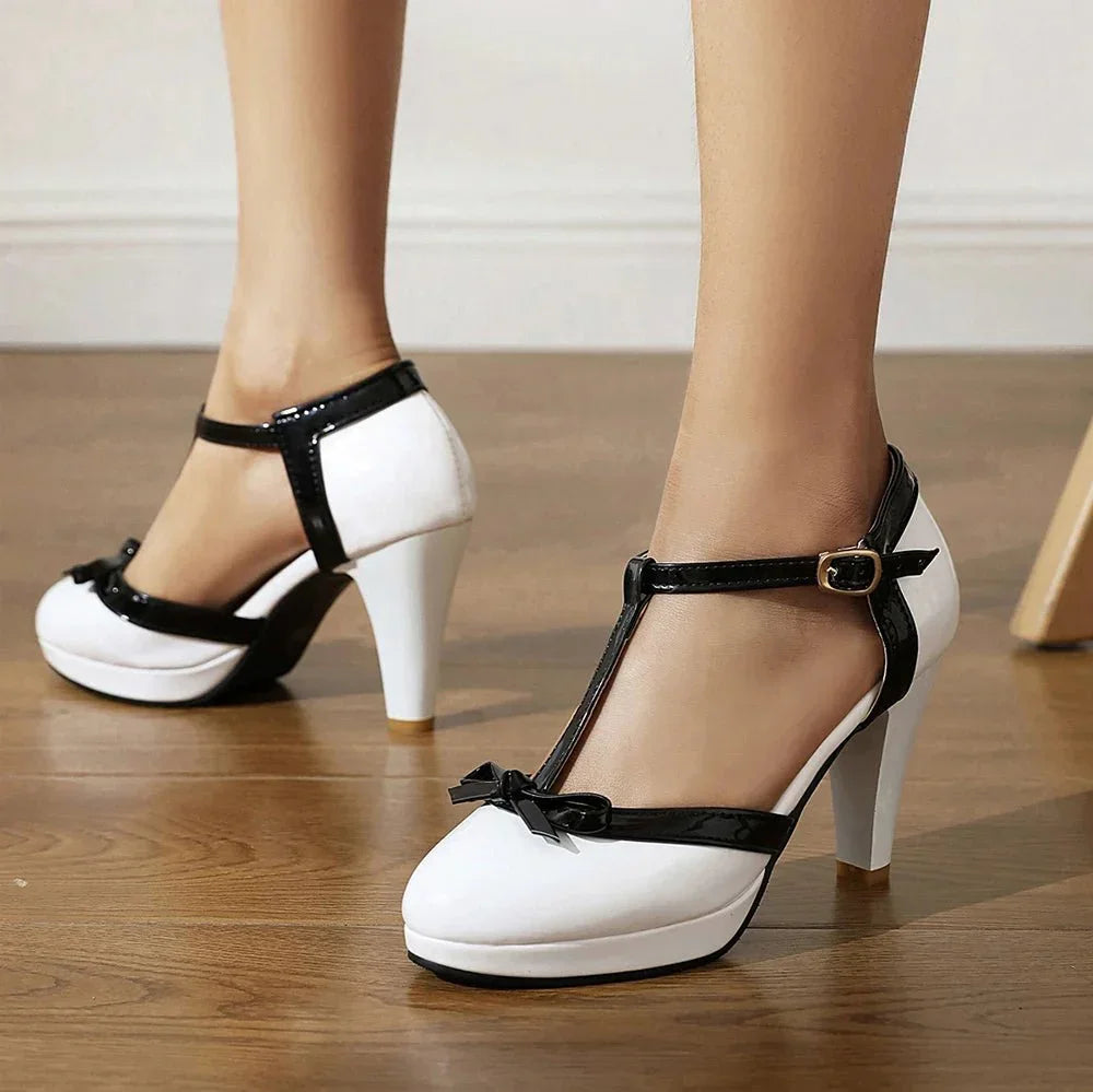 Model wearing heels, seated pose showing ankle buckle