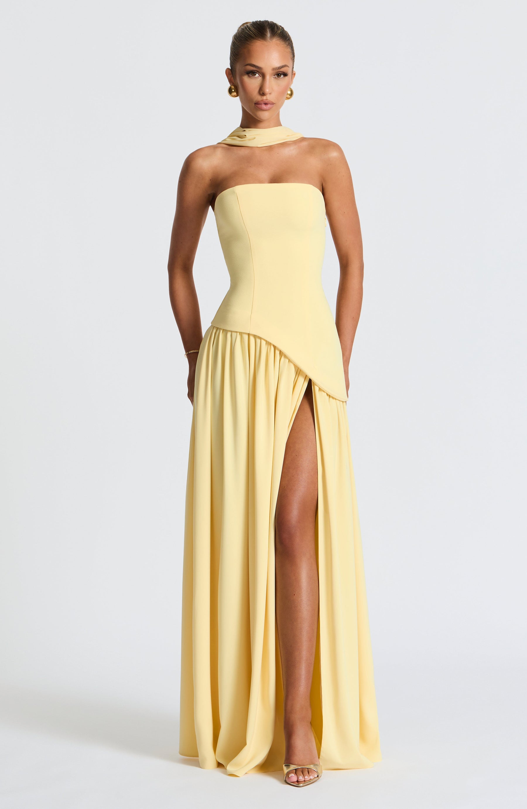 Model posing in strapless maxi dress showing dramatic front slit detail